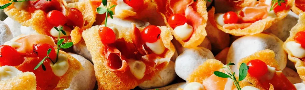 Een smakelijke spread van Italiaans geïnspireerde bruschetta, perfect voor privéfeesten, gegarneerd met rijpe kerstomaatjes, romige mozzarella, gezouten vlees en verse kruiden.